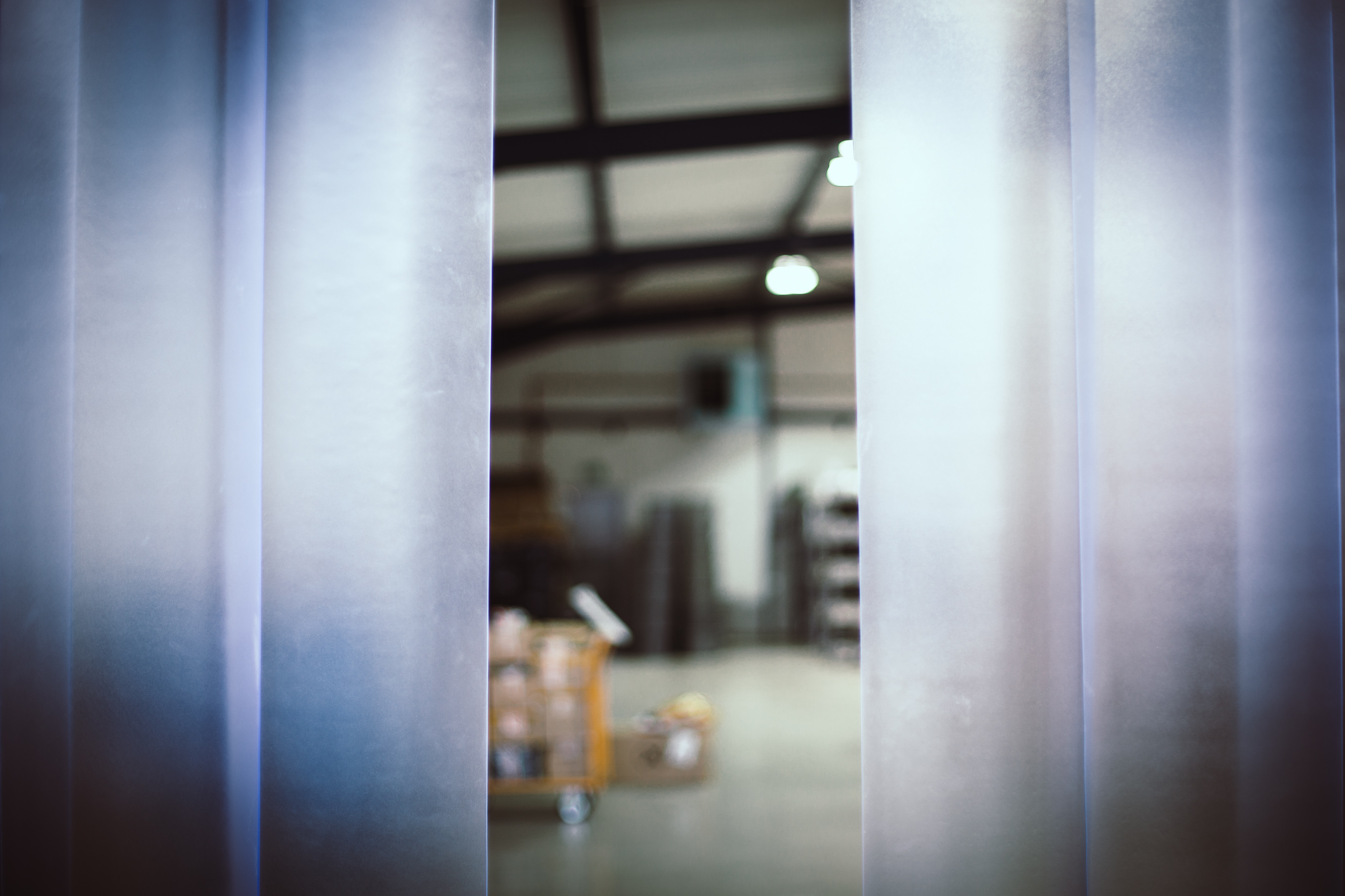 View through clear plastic pvc strip curtain into warehouse